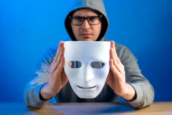 La imagen muestra a una persona con la cara pixelada sosteniendo un papel en blanco, lo que puede simbolizar la falta de identidad o confianza en uno mismo, algo comúnmente asociado con el síndrome del impostor1. El síndrome del impostor se refiere a la incapacidad de internalizar los logros personales y la constante preocupación por ser expuesto como un fraude