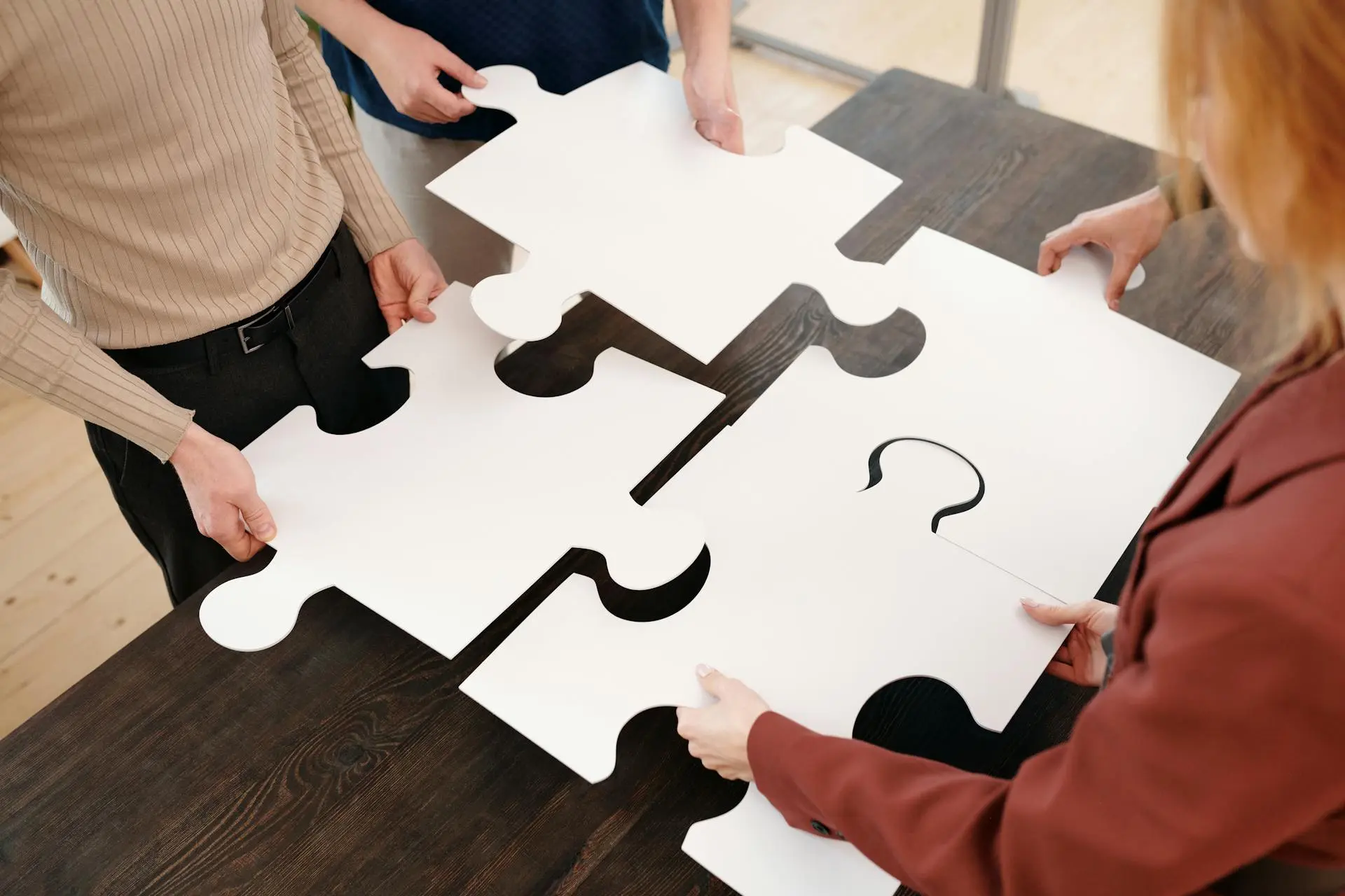 Equipo colaborando en un rompecabezas - Fit Cultural en procesos de contratación