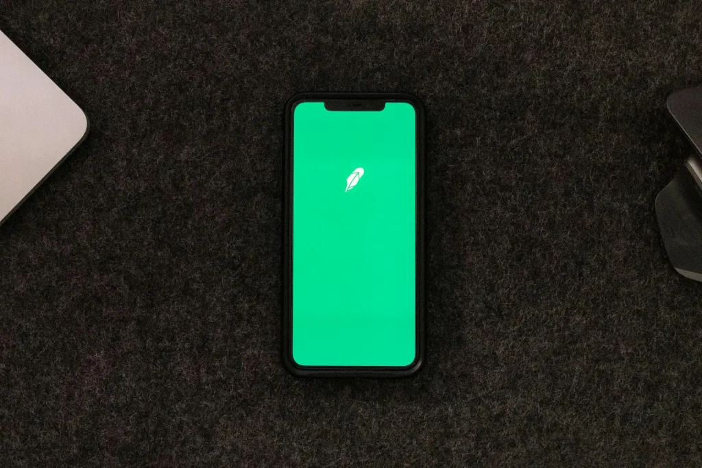 Smartphone mostrando una aplicación nativa en pantalla sobre escritorio oscuro