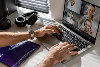 Profesional de IT en videollamada con su equipo remoto desde casa usando laptop